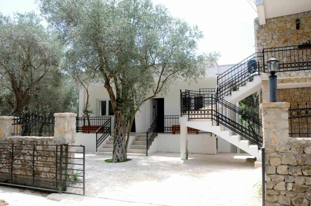 White villa building of Eman Resort among olive trees